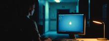 A nurse stares at a monitor in a dimly lit room